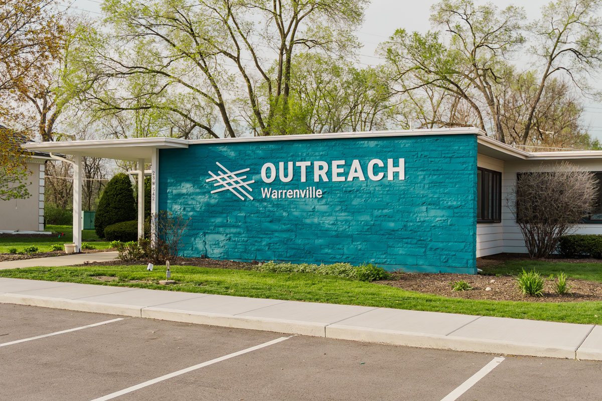 Exterior of the Outreach Warrenville center with teal stone facade and signage