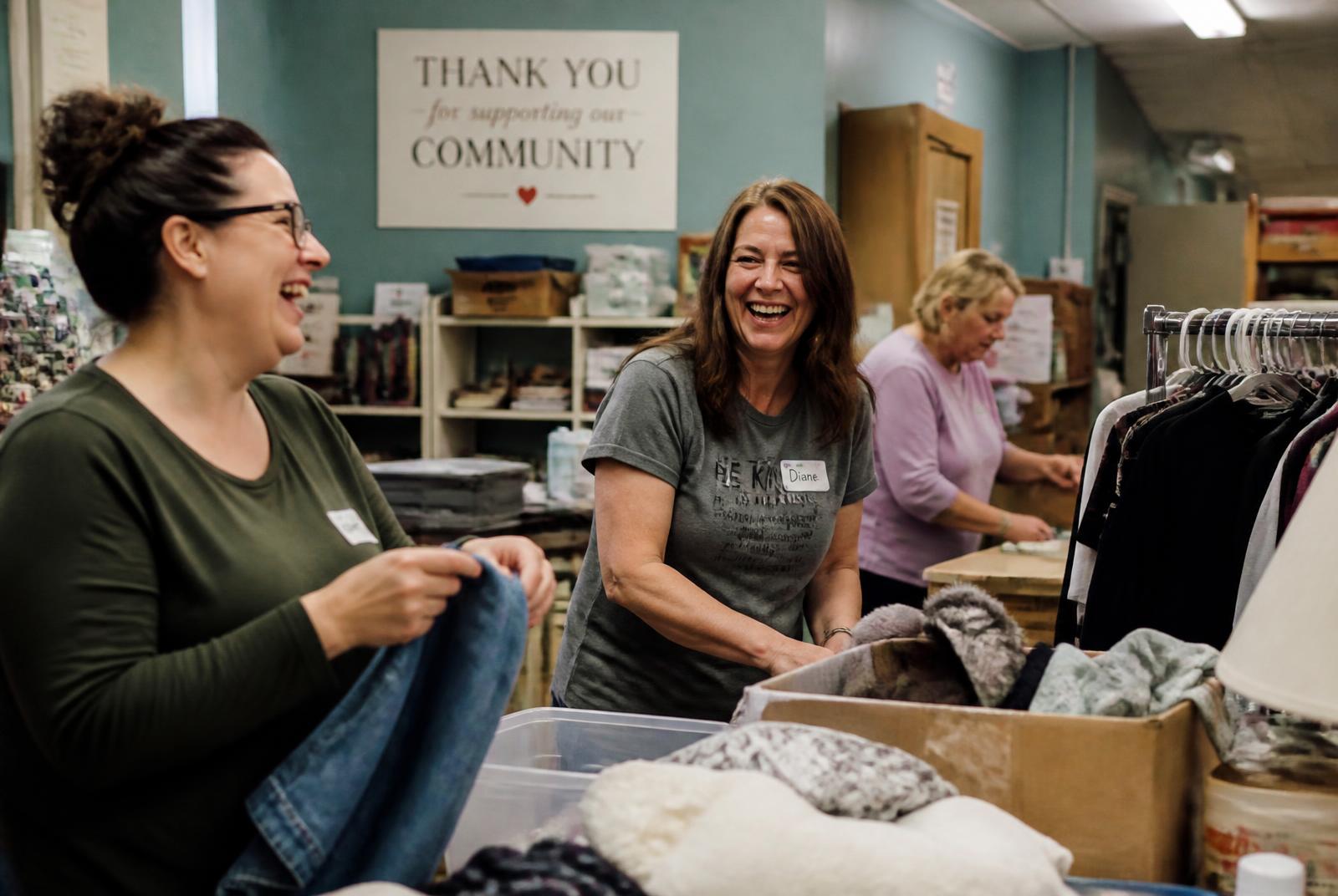 Volunteers sorting donated goods in the back room of a resale shop